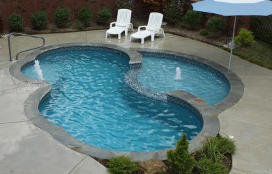 Splash deck with deck bubblers and wide spillover cascade for a fiberglass pool